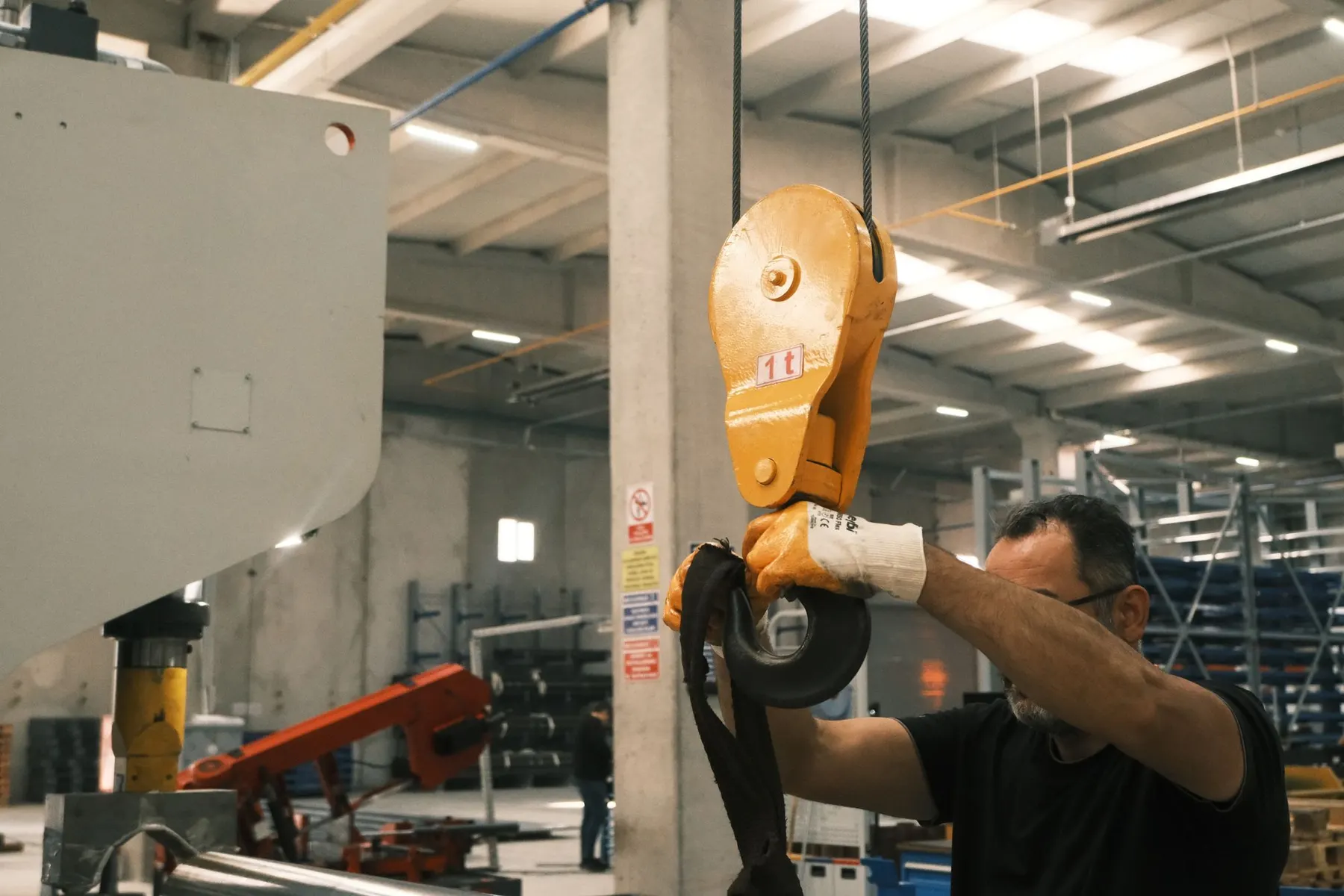 A worker operates industrial lifting machinery in a Konya factory setting.